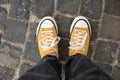 Close Up Feet of girl in stylish casual shoes. Female in yellow sneaker being walking down the street.