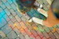 Close-up of feet on the ground surrounded by paints Royalty Free Stock Photo