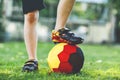 Close-up of feet of kid boy with football and soccer shoes in German national colors - black, gold and red. World or Royalty Free Stock Photo