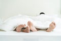 Close up feet of male gay couple lying down on bed, cover with blanket. Romantic man LQBTQ starting foreplay and making love, Royalty Free Stock Photo