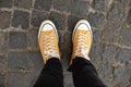 Close up Feet of man while walking commuting to work. Male in yellow sneakers being walking down the street. Confident man Feet Wa Royalty Free Stock Photo