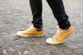 Close up Feet of man while walking commuting to work. Male in yellow sneakers being walking down the street. Confident man Feet Wa Royalty Free Stock Photo