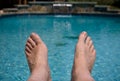 Close up of feet over pool Royalty Free Stock Photo