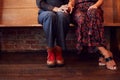 Close Up On Feet Of Same Sex Female Couple Holding Hands Sitting On Bench Together Royalty Free Stock Photo