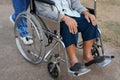 close up feet of senior woman in wheelchair with nurse pushing in park Royalty Free Stock Photo