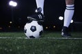 Close up of feet on top of soccer ball on the line, night time in the stadium Royalty Free Stock Photo