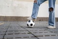 Close up on feet of unknown caucasian female controlling the soccer football ball on the concrete pavement copy space Royalty Free Stock Photo