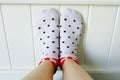Close Up Feet Wearing White Polka Dot Socks in Bedroom Background