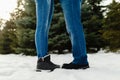 Close-up feet of a young couple in warm winter shoes standing on the snow. The legs of a man and a woman in winter boots stand on Royalty Free Stock Photo