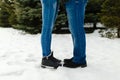 Close-up feet of a young couple in warm winter shoes standing on the snow. The legs of a man and a woman in winter boots stand on Royalty Free Stock Photo