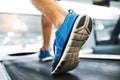 Feet of young man in gym running on treadmill. Royalty Free Stock Photo