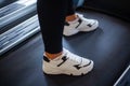 Close-up of feet of young woman in sportswear is running on a treadmill in the gym