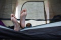 Close up on feets of child while lying down in tent on campsite.