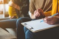 Married couple signing document with surrogate expectant mother