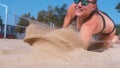 CLOSE UP: Female athlete dives into sand and saves a point during volleyball Royalty Free Stock Photo