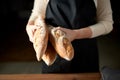 close up of female baker holding baguette bread Royalty Free Stock Photo