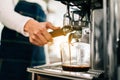 Close-up female barista hand inserts the metal filter in the coffee machine, waiting for pouring hot black coffee inside beaker. Royalty Free Stock Photo