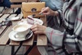 Close up of female with blue manicure having cheesecake pie and cappuccino at coffee place. Royalty Free Stock Photo