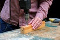 Close-up of female carpenter drilling wooden plank to make hole. DIY, woodwork concept Royalty Free Stock Photo