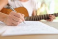 Close-up of female composer writing music notes in notebook. Royalty Free Stock Photo