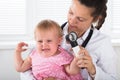 Doctor Examining Ear Of Little Girl With Dermatoscope Royalty Free Stock Photo