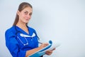 Close-up of a female doctor filling up medical form at clipboard while standing straight in hospital Royalty Free Stock Photo