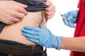 Close-up of female doctor giving injection to male patient belly