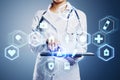 Close up of female doctor hand pointing at tablet with creative glowing blue medical interface hologram on blurry background. Royalty Free Stock Photo