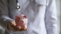 Close up of female doctor hold piggy bank Royalty Free Stock Photo