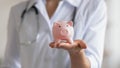 Close up of female doctor hold piggybank collect donation