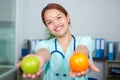 close up female doctor holding apple and orange Royalty Free Stock Photo