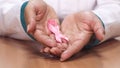 Close up of a female doctor holding pink ribbon for breast cancer awareness Royalty Free Stock Photo