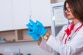 Close up of a female doctor  nurse  holding a syringe while standing in a medical office Royalty Free Stock Photo