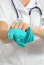 Close up of a female doctor putting a green latex gloves Royalty Free Stock Photo