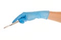 Close up of female doctor's hand in blue sterilized surgical glove with scalpel against white