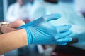 Close up of female doctor& x27;s hands putting on blue sterilized surgical gloves in the office Royalty Free Stock Photo