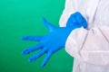 Close up of female doctor`s hands putting on blue sterilized surgical gloves in the office. Royalty Free Stock Photo