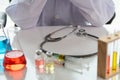 Female doctor or scientist with medical equipment composition, stethoscope, vaccine, syringe and test tube making research in