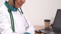 Close up of a female doctor smiling filling medical papers at work