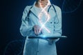 Close up of female doctor using tablet with glowing DNA helix hologram on background. Medicine and bioengineering concept