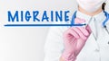 Close up female doctor writing word MIGRAINE with marker. Medical concept Royalty Free Stock Photo