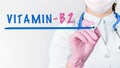 Close up female doctor writing word VITAMIN B2 with marker. Medical concept