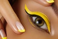 Close-up Female Eye with bright yellow Eyeliner Makeup. Neon Disco make-up and Fashion Manicure. Summer beauty style Royalty Free Stock Photo