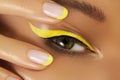 Close-up Female Eye with bright yellow Eyeliner Makeup. Neon Disco make-up and Fashion Manicure. Summer beauty style Royalty Free Stock Photo