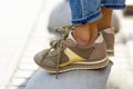 Close-up of female feet in beige sneakers. Woman in fashionable