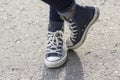 Women`s feet in sneakers are standing on the sidewalk Royalty Free Stock Photo