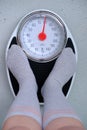 Close-up of female feet on the floor in gray light cotton socks on floor mechanical scales in vintage style, concept of women`s