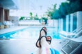 Close up female feet in sandals relaxing near blue water of the swimming pool in hotel in evening time. Calm, slow, harmony Royalty Free Stock Photo