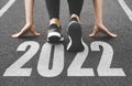 close-up of female feet in sneakers at the start. Beginning and start of the new year 2022, goals and plans for the next Royalty Free Stock Photo