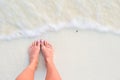 Close up of female feet on white sandy beach Royalty Free Stock Photo